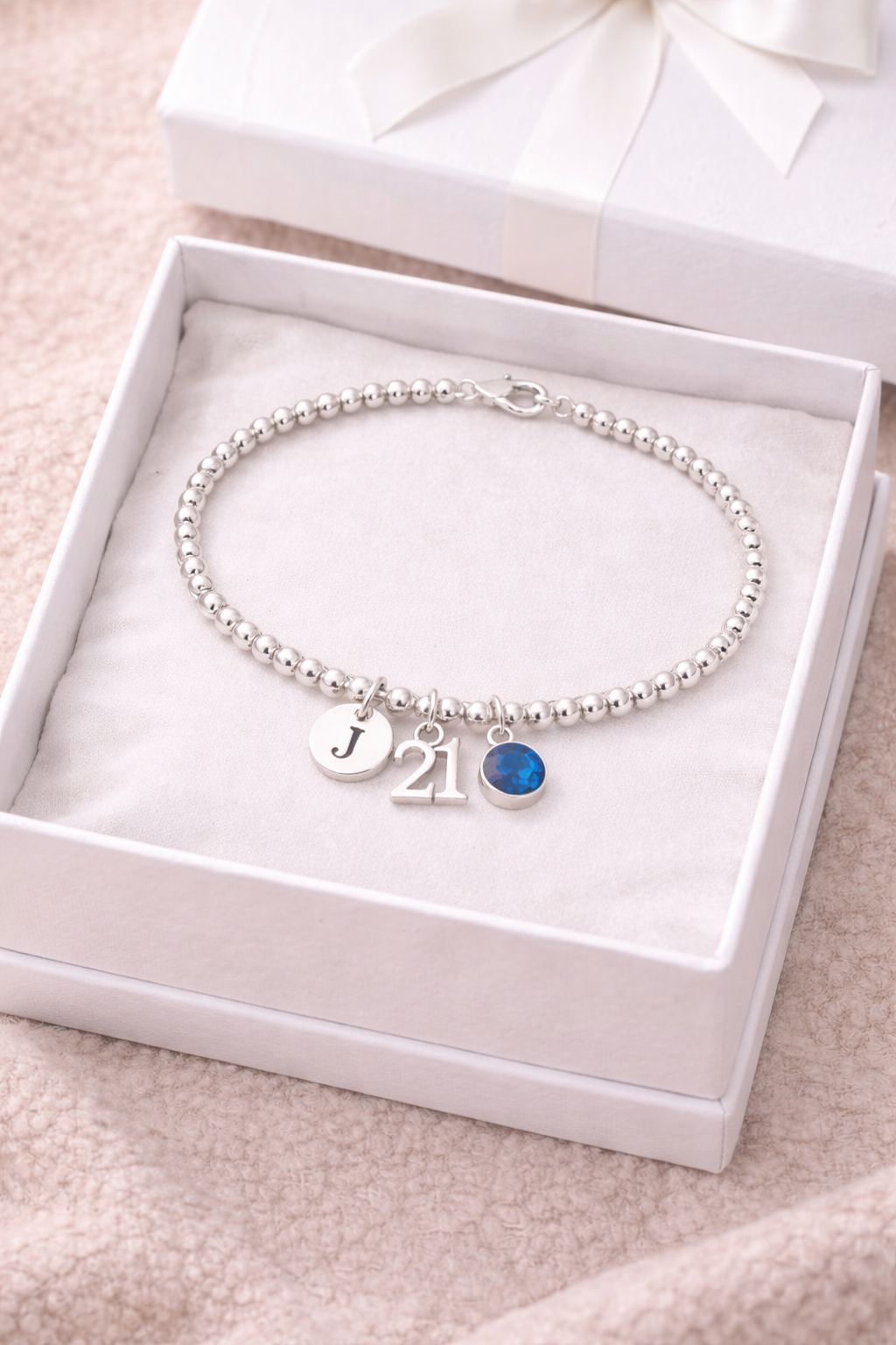 21st birthday bracelet worn on wrist with initial and birthstone charm