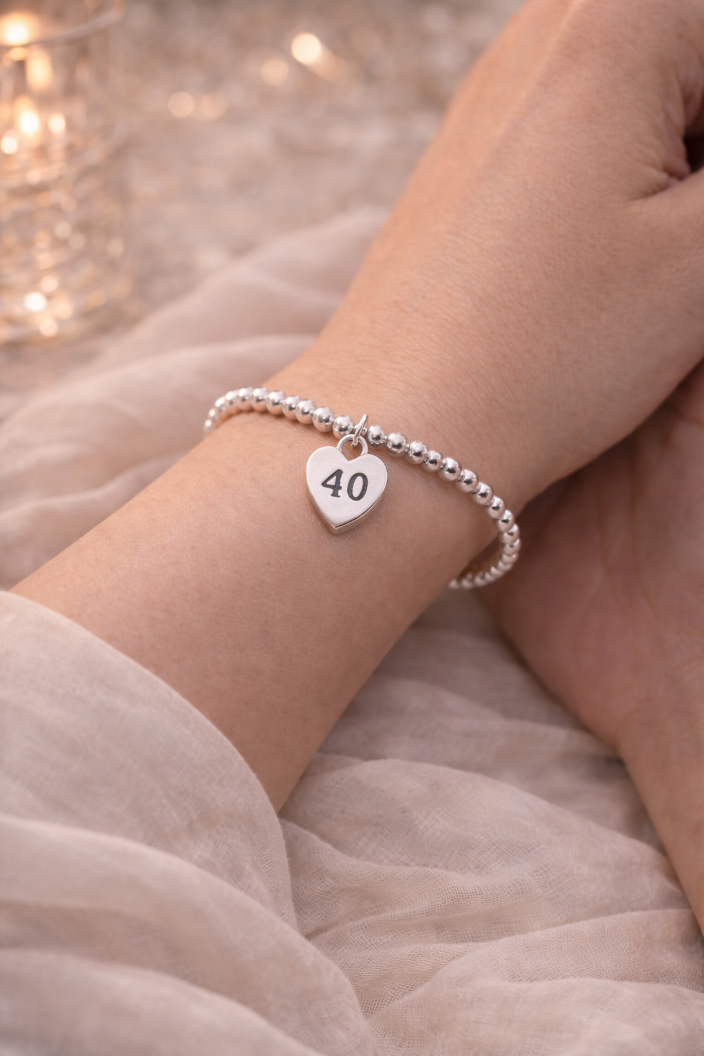 Close-up of silver bracelet with heart charm engraved 40